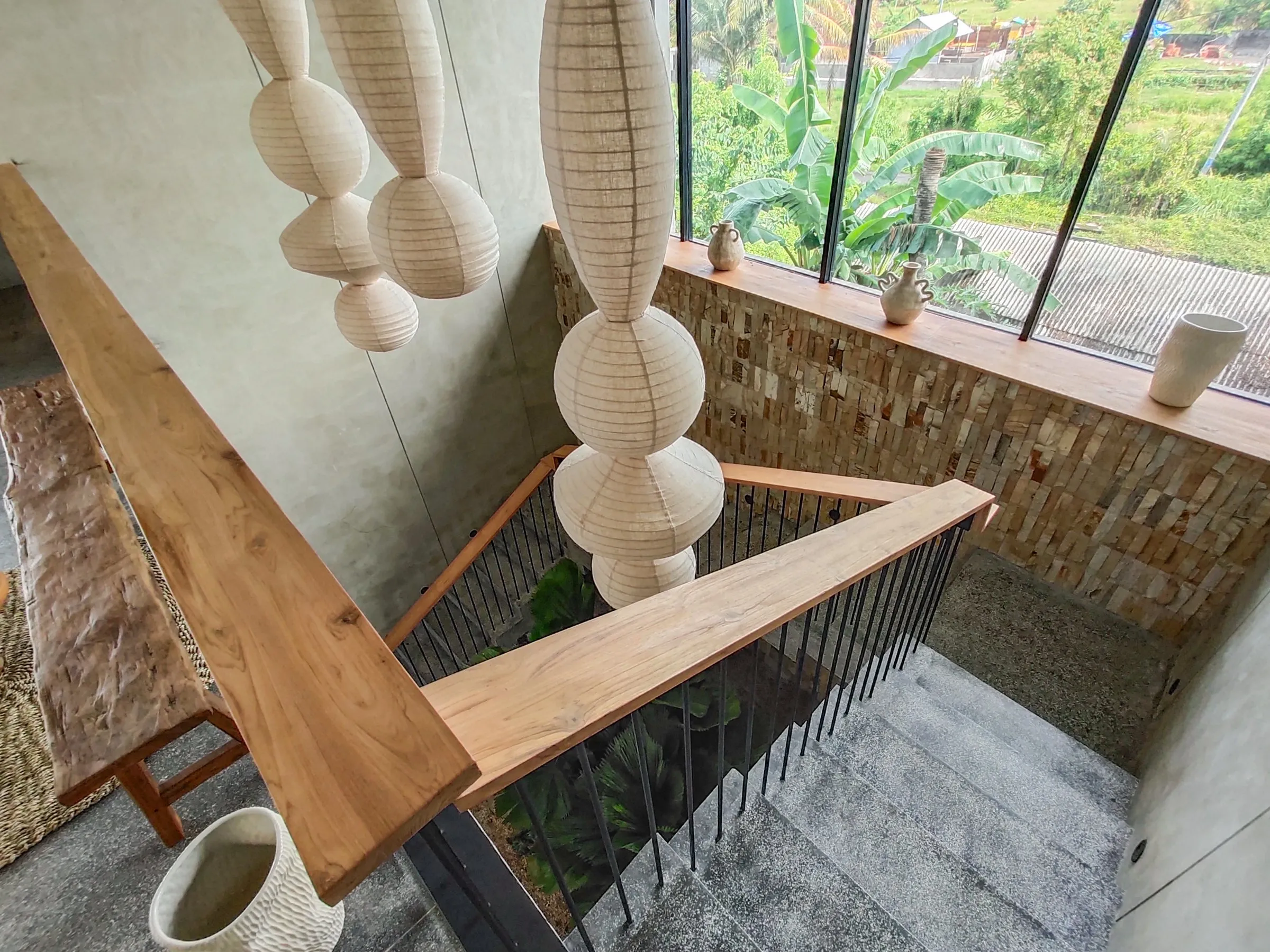 Teak handrail following the staircase void.
