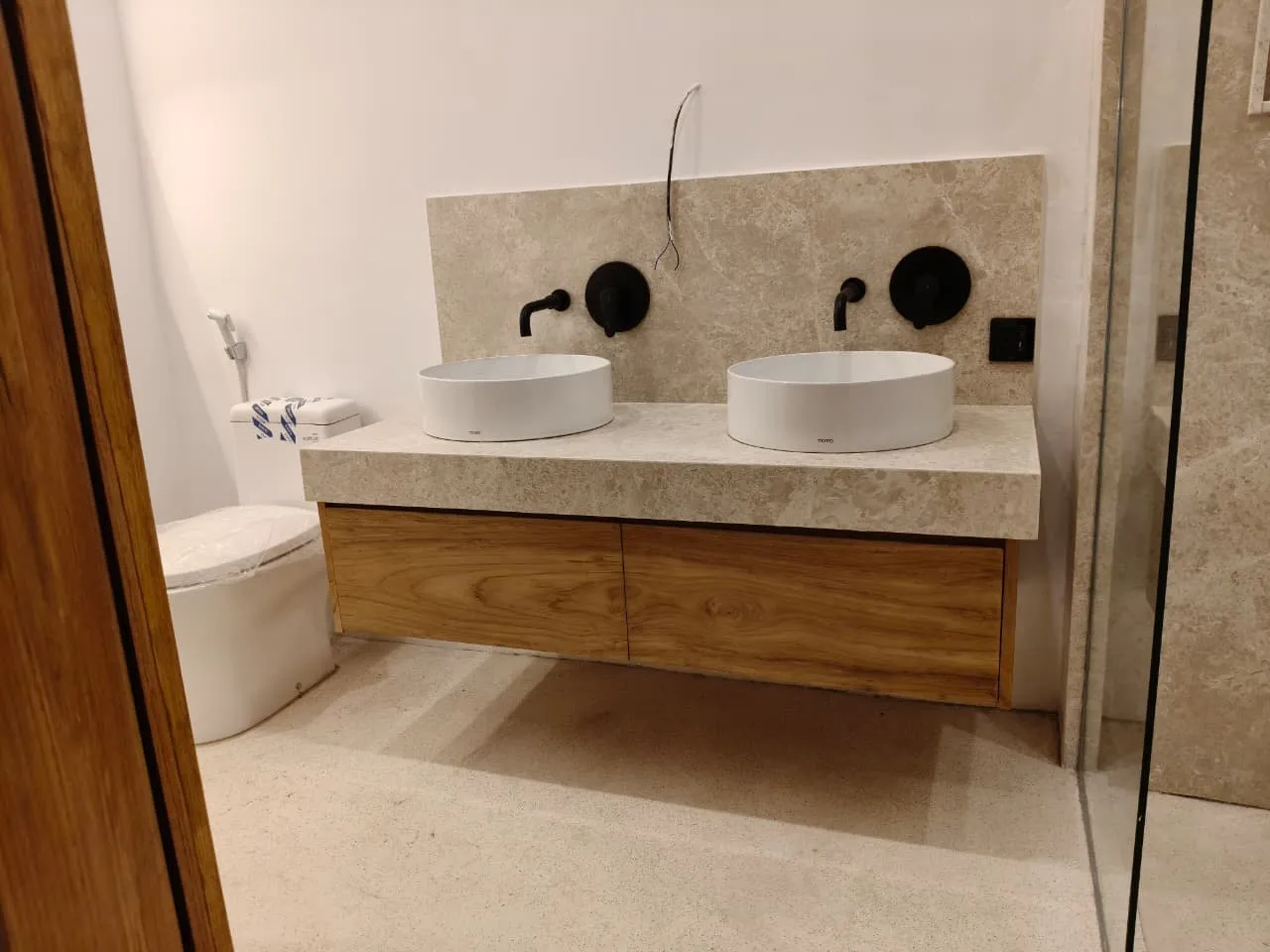 Teak vanity with two vessel basins.