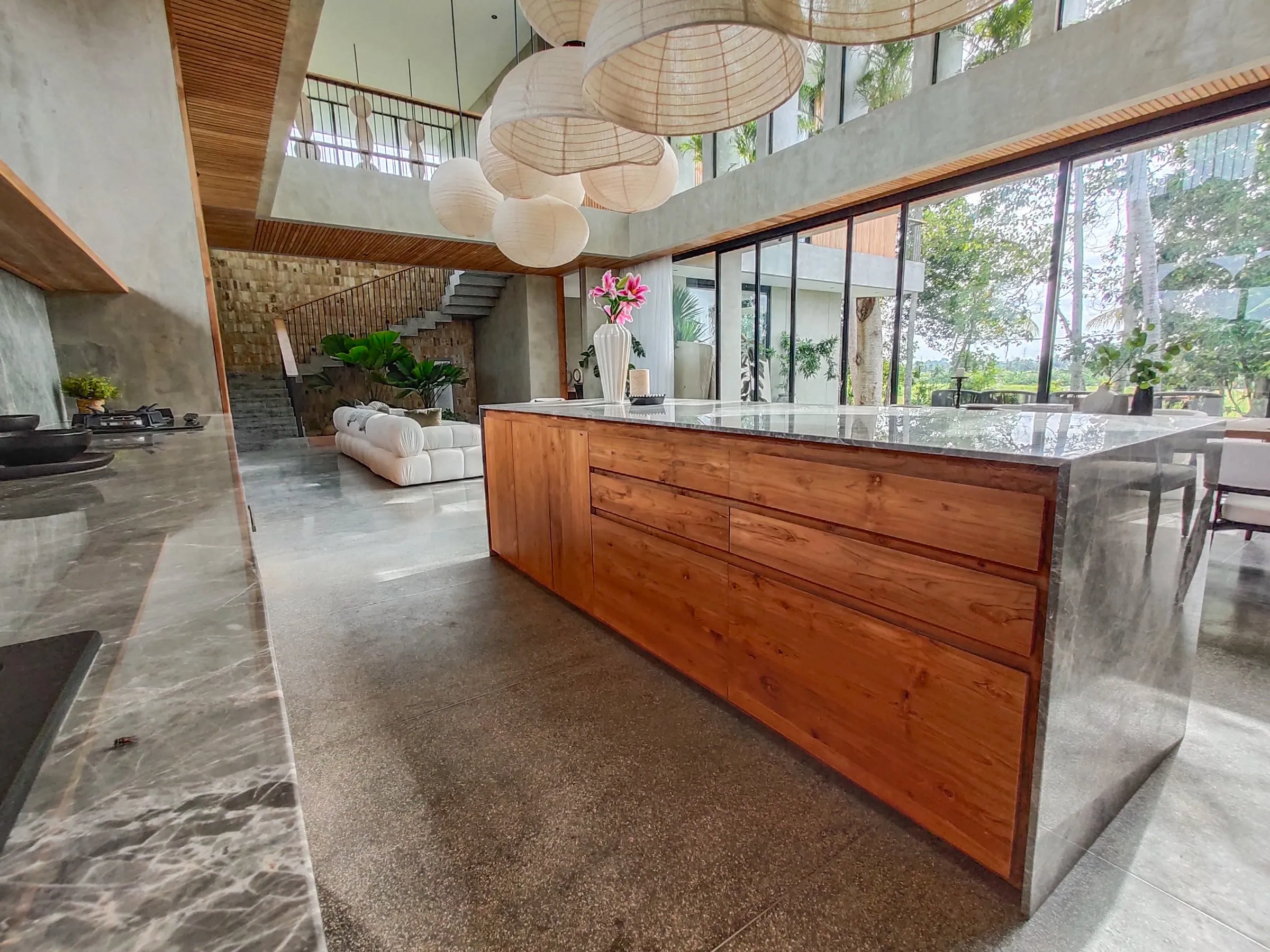 Teak kitchen island under the double-height ceiling.