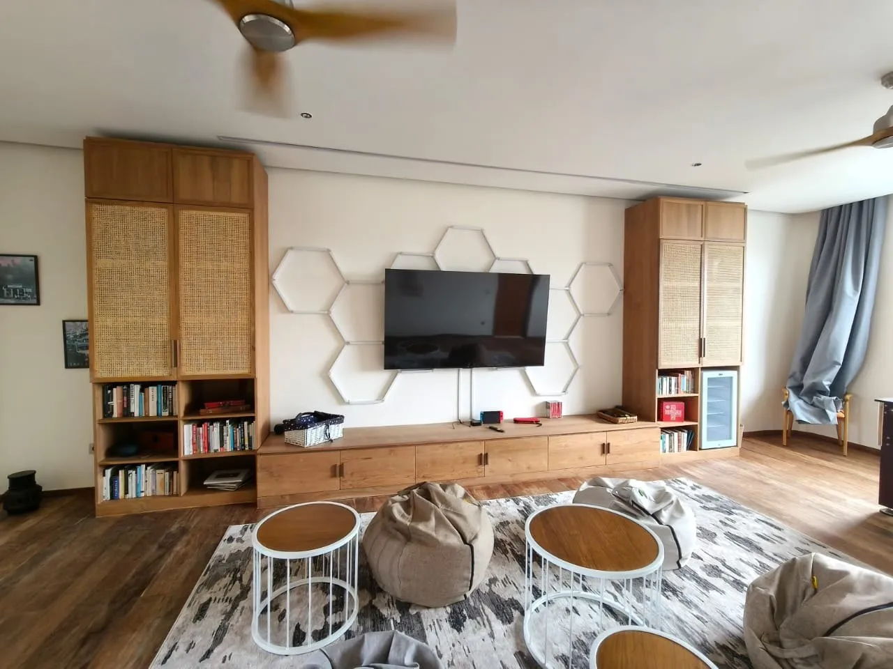 Living room with teak media wall and rattan-panel cabinets.