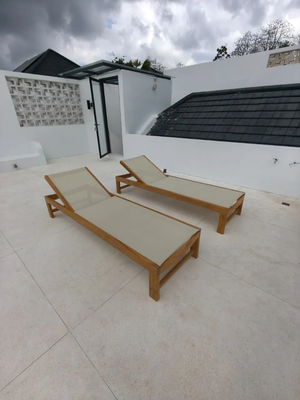 Teak sun loungers on a roof terrace.