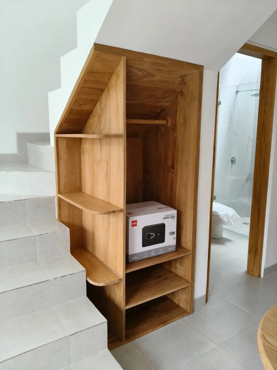 Under-stair teak storage with shelving.